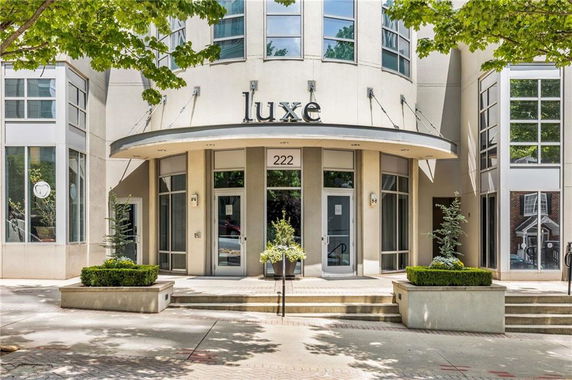 Front view of a modern building with large windows and an entrance labeled 'Luxe'.