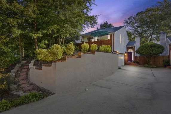 Front view of a two-story house with a terrace and garage.