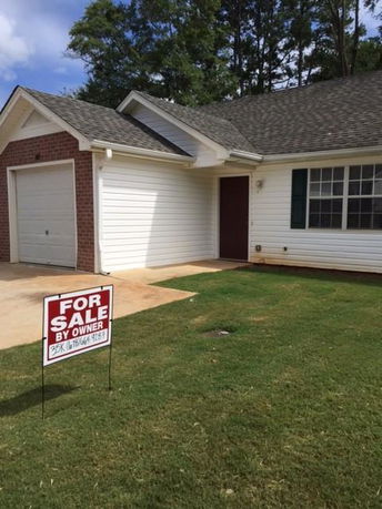 Front view of a single-story house with a garage for sale by owner.