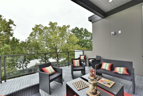 Rooftop seating area with wicker furniture and colorful cushions.