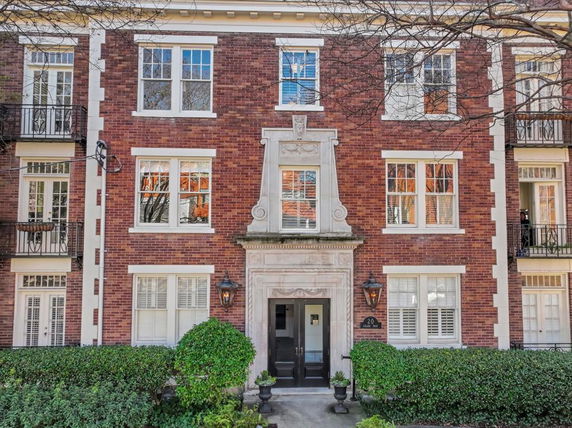 Front view of a brick residential building with multiple windows and an entrance.