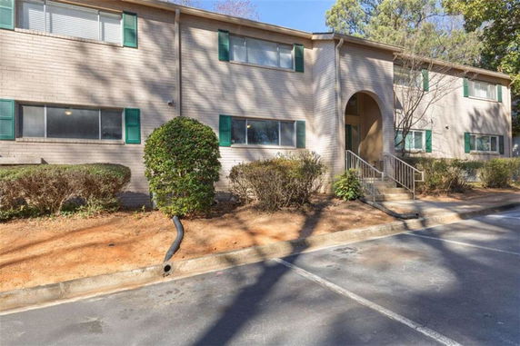 Front view of a two-story residential building with green shutters.