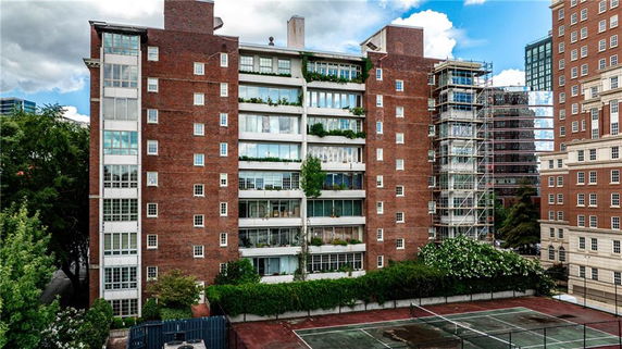 Front view of a multi-story brick building with balconies.