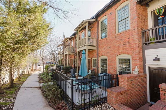 Front view of a two-story brick apartment building with balconies.