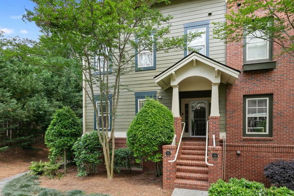 Front view of a house with brick and siding exterior and a small porch entrance.