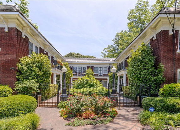 Front view of a two-story brick building with columns and a gated entrance.