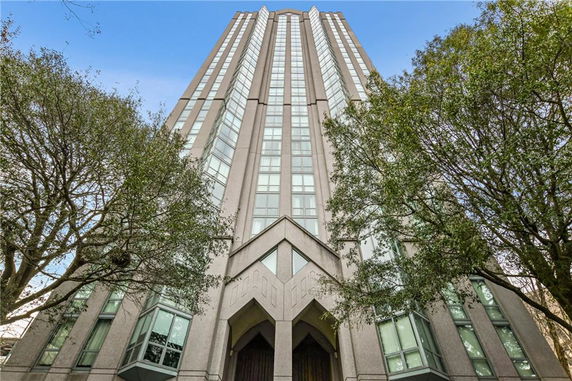 Front view of a tall building with symmetrical design and large windows.