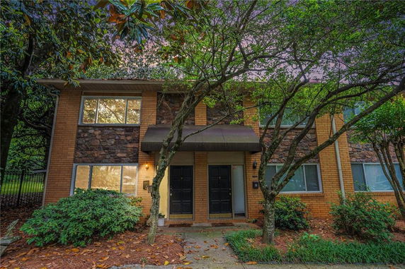 Front view of a two-story house with a brick and stone exterior.