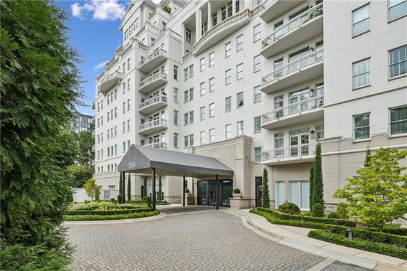Front view of a multi-story residential building with balconies and a covered entrance.
