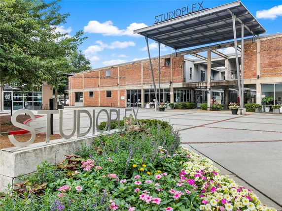 Front view of a brick commercial building with a large metal awning and 'STUDIOPLEX' sign.