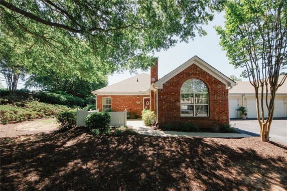 Front view of a single-story brick house with a large arched window.