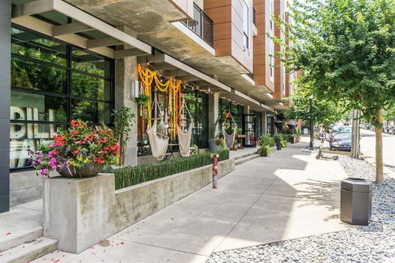 Front view of a modern building with hanging chairs and outdoor decorations.