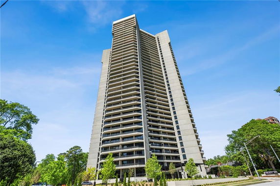 Front view of a tall apartment building with multiple balconies.