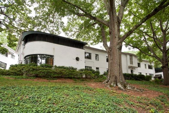 Front view of a large two-story building with white exterior and curved windows.