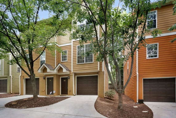 Front view of a multi-story townhouse with a garage and entrance door.