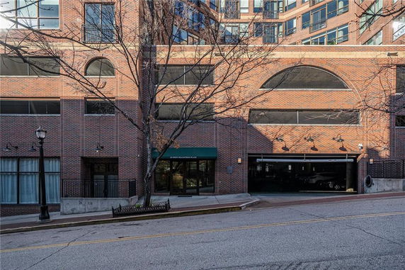 Front view of a multi-story brick building with large windows and an entrance.
