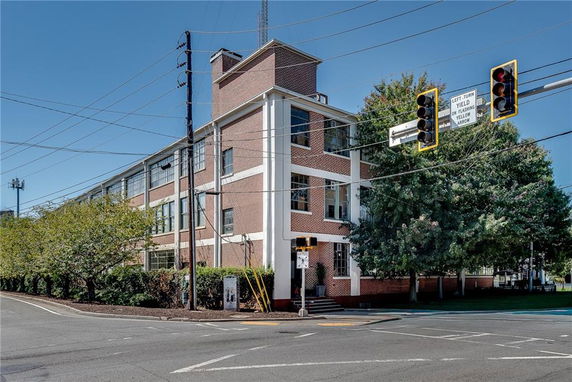 Front view of a multi-story brick building with large windows.