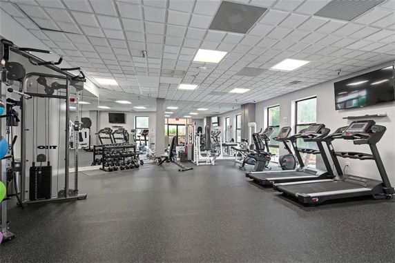 Interior of a gym with treadmills, weight machines, and free weights.