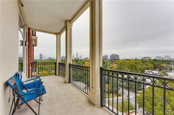 View from a balcony overlooking a cityscape with distant buildings.