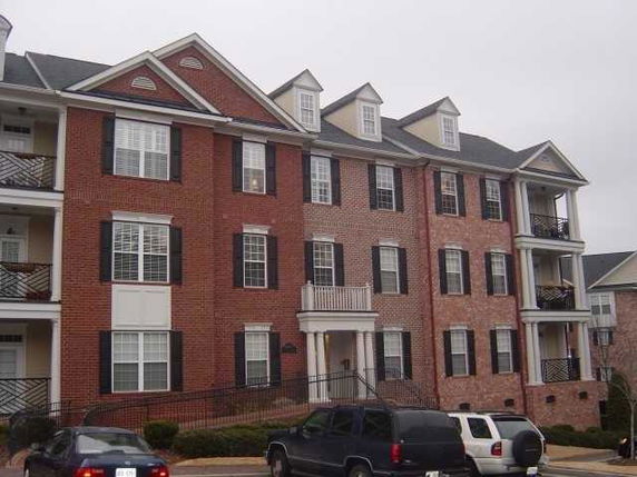 Front view of a multi-story brick apartment building with balconies.