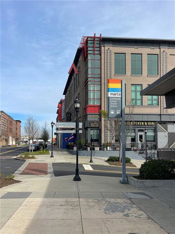 Front view of a multi-story building with large windows and signs.