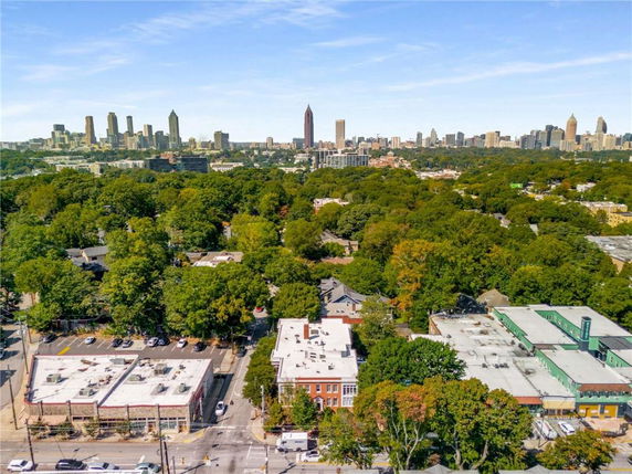 Wide angle view of a cityscape with buildings and tree-covered areas in the foreground.