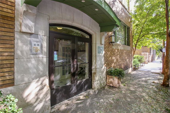 Front entrance of a building with a glass door and brick exterior.