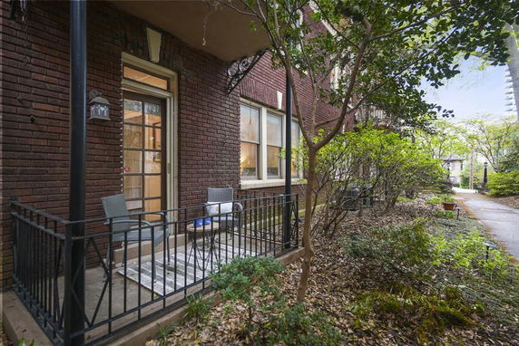 Front view of a brick building with a small porch and metal railings.