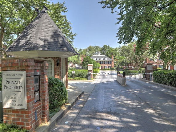 Front view of a brick entrance gate to a private property with keypad and security features.