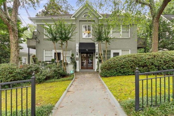 Front view of a two-story house with a pathway leading to the entrance.