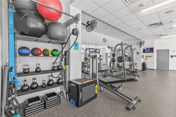 Interior view of a gym with exercise equipment and weights.