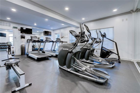 Interior view of a gym with exercise equipment including treadmills and elliptical machines.