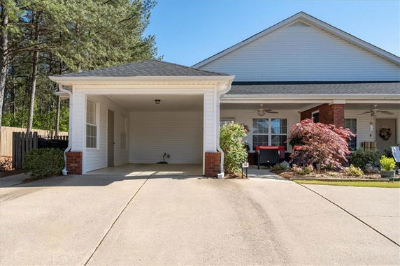 Front view of a single-story house with a carport and paved driveway.