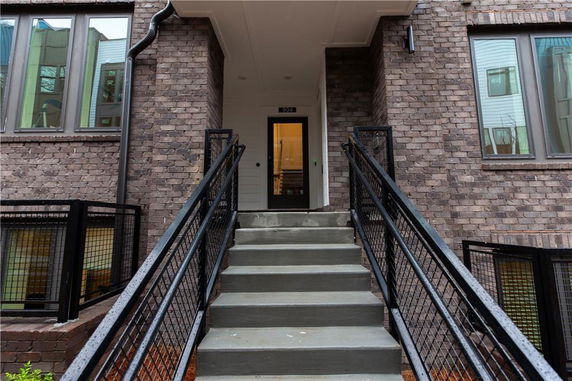 Front view of a building entrance with a brick exterior and steps leading up.