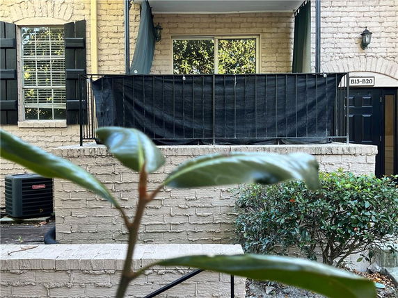 Front view of a building with a small balcony and a door labeled B13-B20.