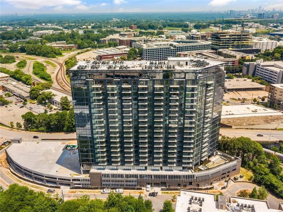 Aerial front view of a high-rise building with glass facade and multiple balconies.