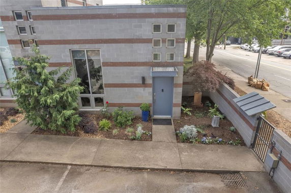 Front view of a modern building with rectangular windows and a blue door.