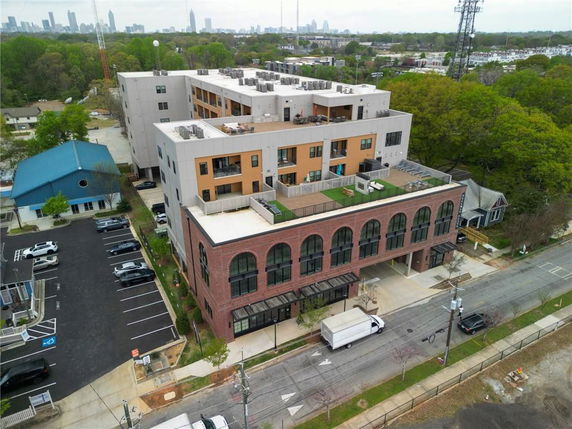 Aerial view of a multi-story building with a brick facade and a rooftop terrace.