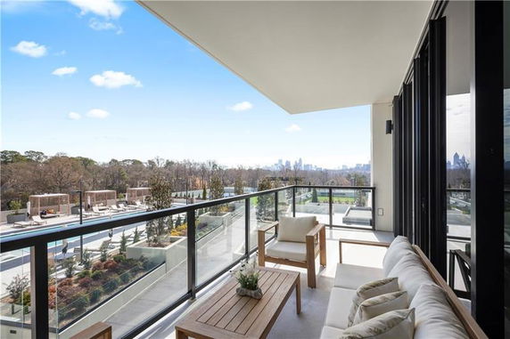 Balcony view overlooking distant city skyline and surrounding greenery.