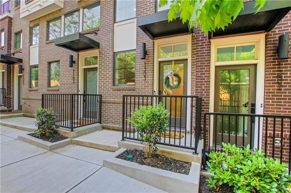 Front view of a multi-story brick townhouse with small front porches.