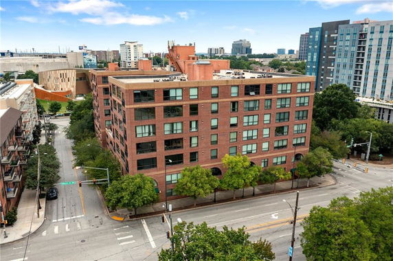 Front view of a multi-story brick apartment building on a street corner.
