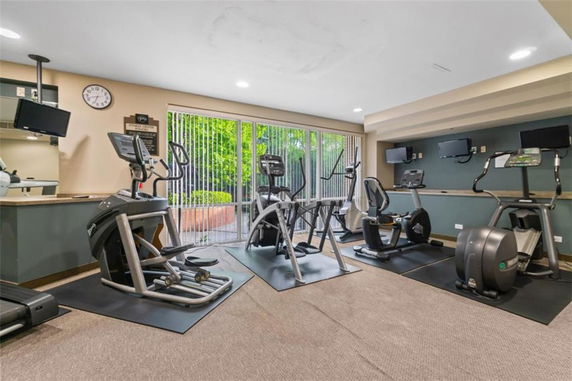 Indoor gym area with exercise equipment and large windows.