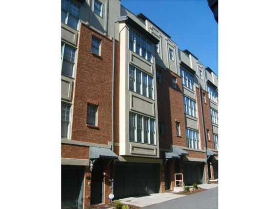 Front view of a multi-story residential building with brick and stucco facade.