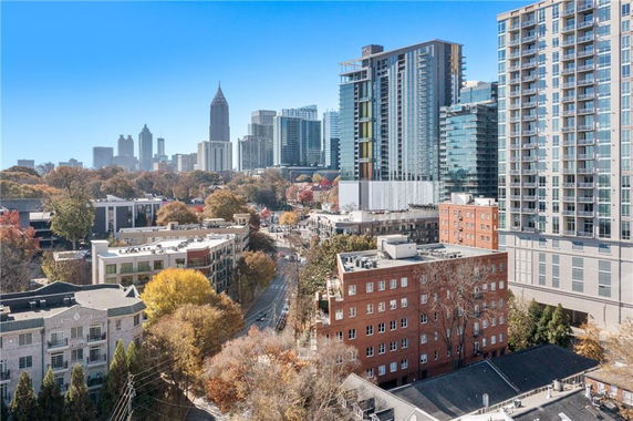 Aerial view of a cityscape with multiple high-rise buildings and tree-lined streets.