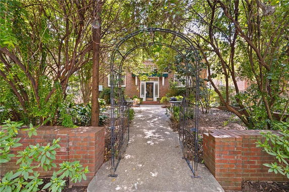 Front view of a brick house with a garden pathway leading to the entrance.