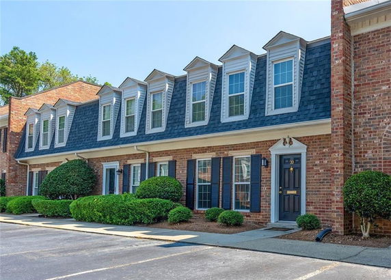 Front view of a brick townhouse with multiple dormer windows.