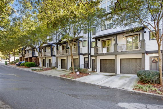 Front view of a row of multi-story townhouses with garages.