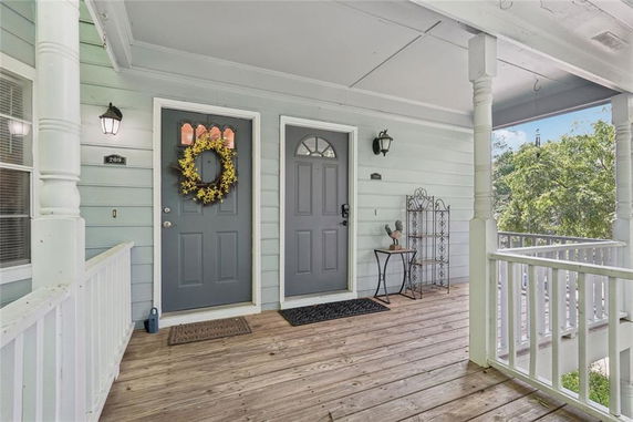 Front view of a house with two gray doors and a wooden porch.