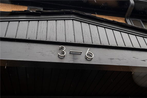 Front view of a house with a visible number 3-6 on a wooden facade.