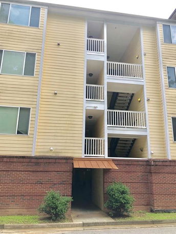 Front view of a multi-story apartment building with balconies.